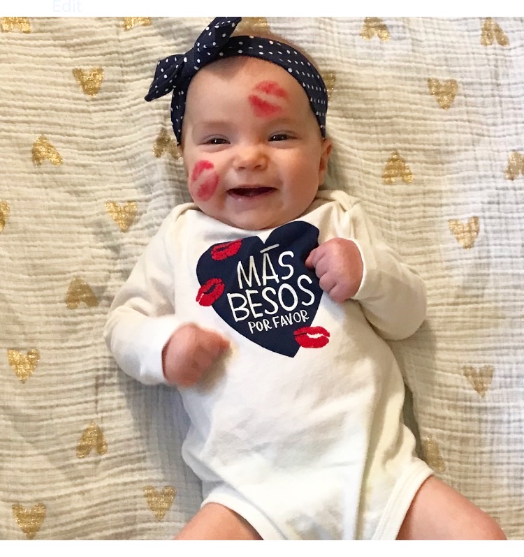 baby smiling with kisses on face out of lipstick