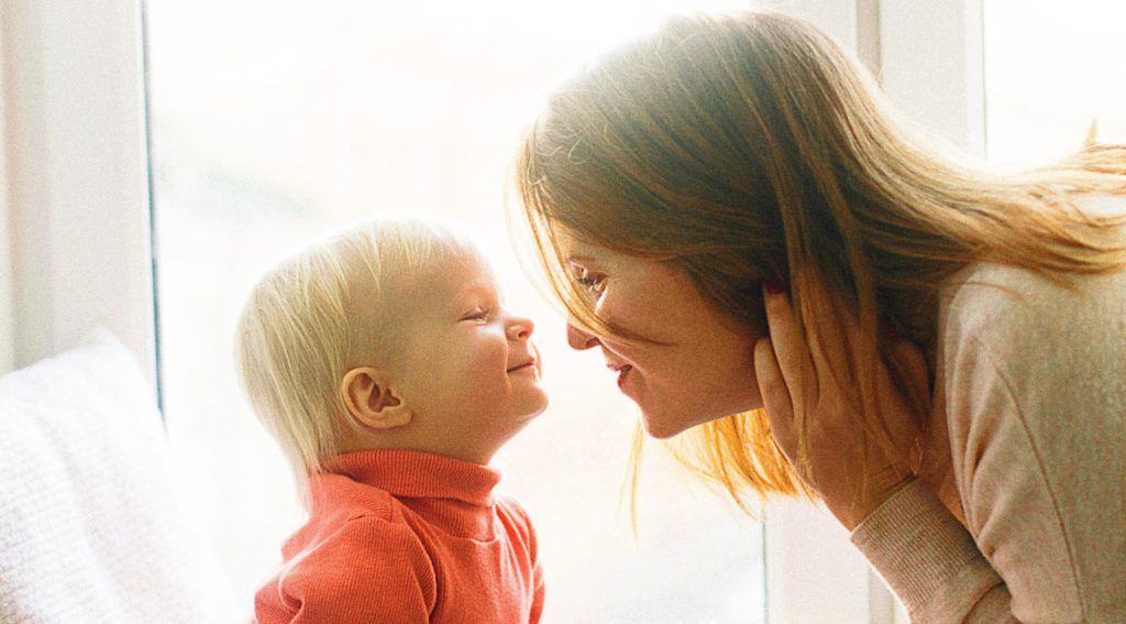 mom and child sitting face to face at each other's level