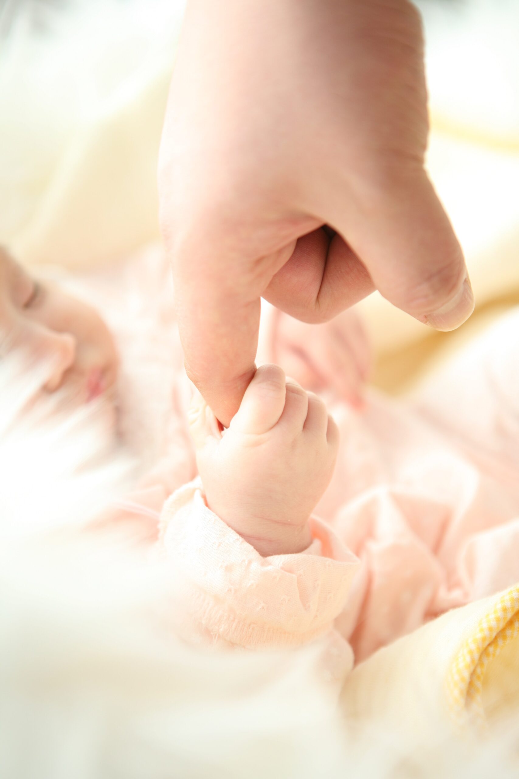Baby holding person's finger