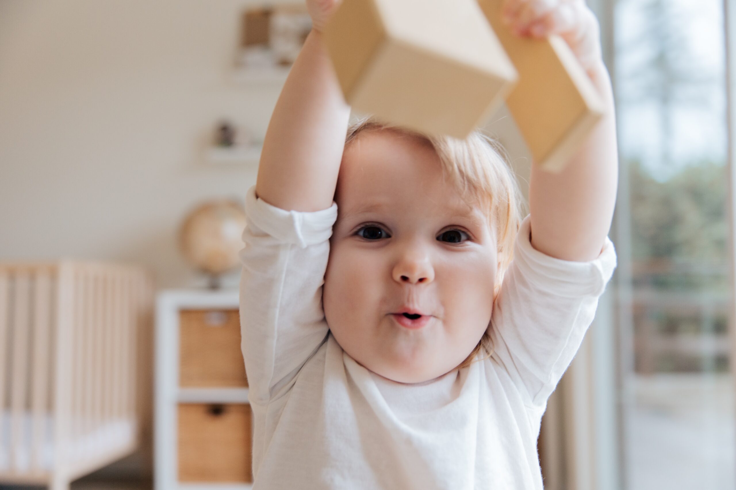 toddler lifting a block above his head