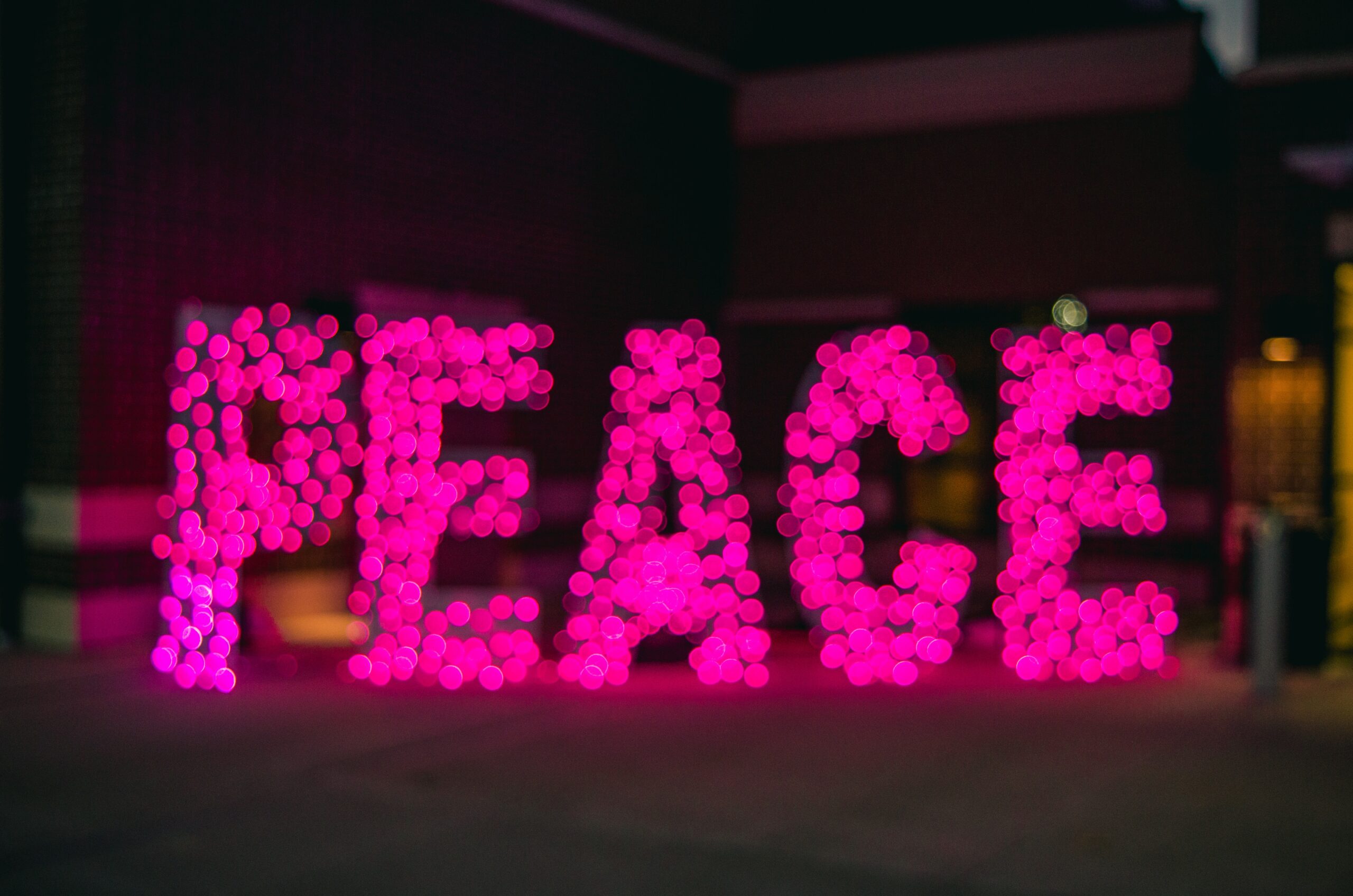 the word peace in pink lights