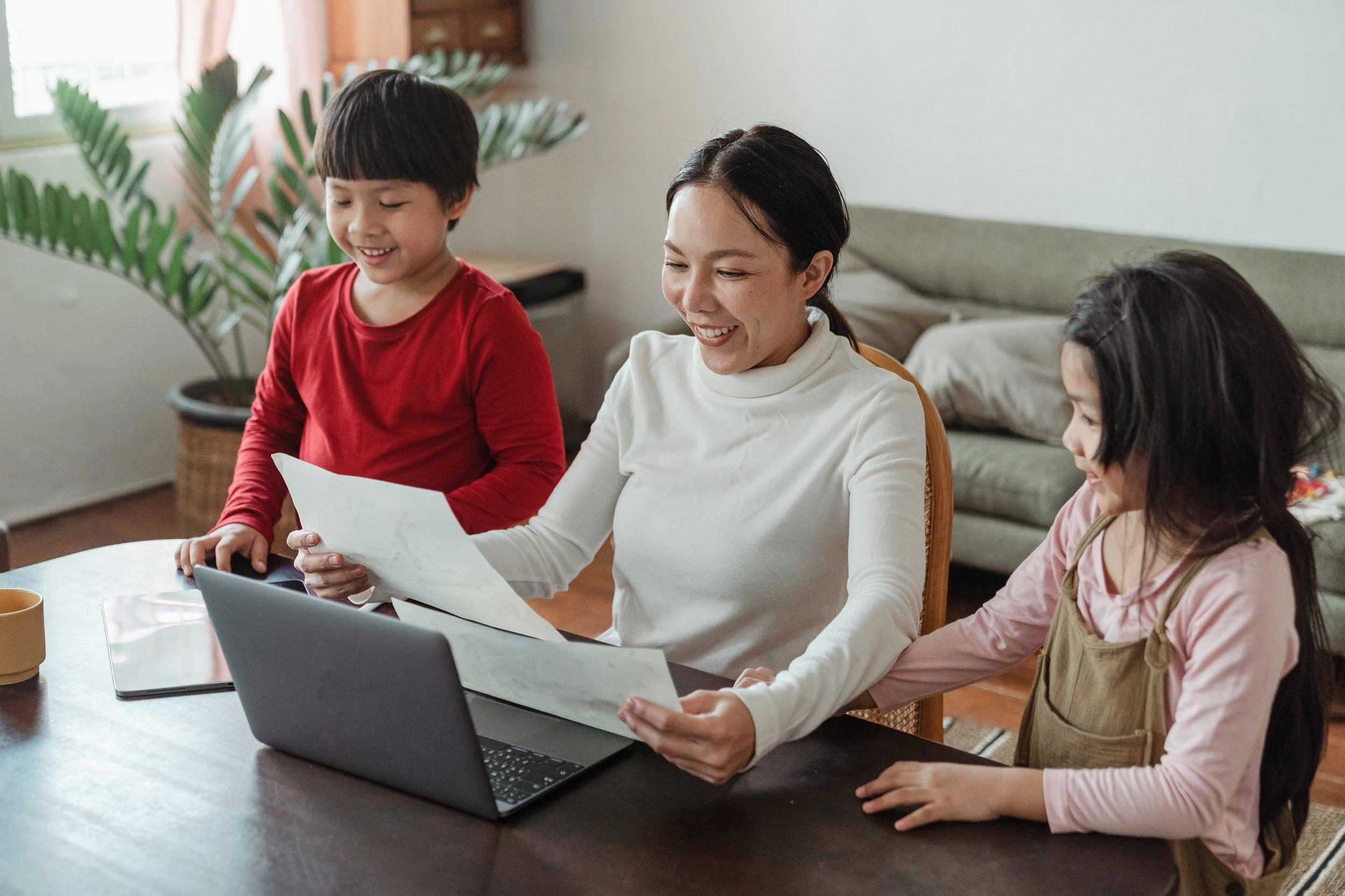 smiling working mom with boy and girl at desk in home