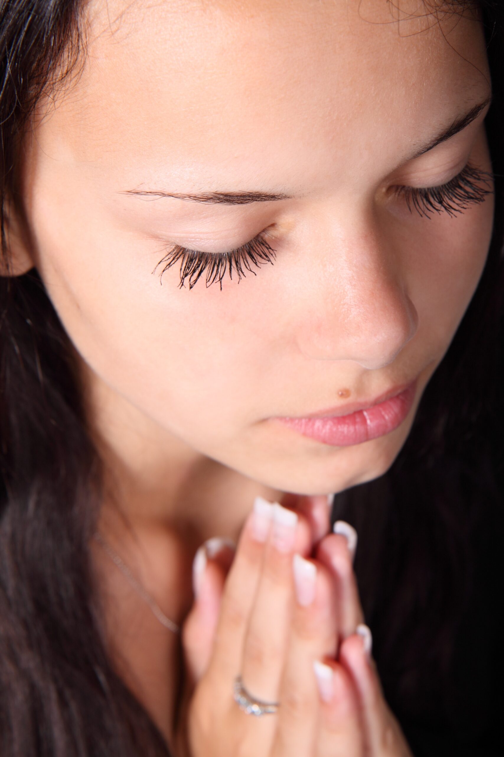teen girl praying with hands clasped