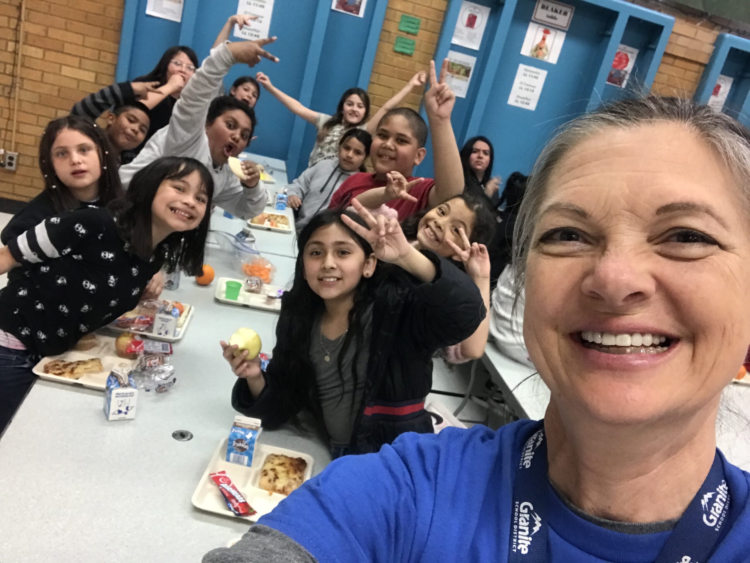 teacher with happy fourth grade students in background
